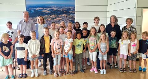 Alle Ferienkinder in Startstellung zur Rathaus-Rallye mit Bürgermeister Dr. Ralf Göck und Alexandra Eichler (links) sowie Marion Thüning, gesamtverantwortlich für das Kinderferienprogramm 2024, und Irina Haas-Ritter im Sitzungssaal des Rathauses.