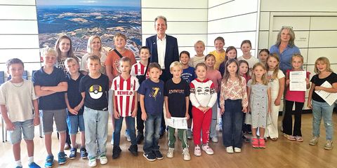 Alle Ferienkinder in Startstellung zur Rathaus-Rallye mit Bürgermeister Dr. Ralf Göck und Marion Thüning (rechts), gesamtverantwortlich für das Kinderferienprogramm 2025, und Marie Schäfer mit Ivona Szutra im Sitzungssaal des Rathauses