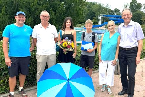 Bäderleiter Patrick Berndt (v. l. n. re.), Sachgebietsleiter Dirk Faulhaber, Kiosk-Pächterin Britta Fassner und Bürgermeister Dr. Ralf Göck gratulieren Anna und Mika zu ihrem Jubiläumsbesuch