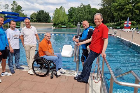 Bürgermeister Dr. Ralf Göck, Bäderleiter Patrick Berndt, Behindertenbeauftragter Rudi Bamberger, Dirk Faulhaber und Kai Rill von der Gemeindeverwaltung und Schwimmmeister Marc Herbel freuen sich über den neuen Becken-Lifter.