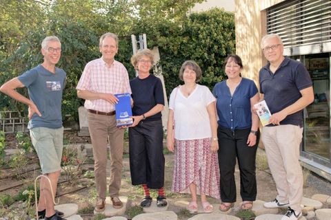 Bürgermeister Dr. Göck überreicht Familie Mack ein Präsent. Klimaschutzmanagerin Birgit Sehls, Energieberaterin Christine und KLiBA Geschäftsführer Dr. Klaus Keßler (v.li.n.re) freuen sich über die Sanierungs-Erfolge.