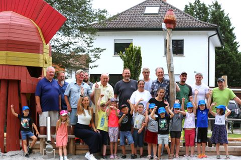 Gemeinderäte, Bauhof-Team und Bürgermeister (hinten) und die Schulanfänger vom Haus der Kinder (vorn) mit ihrer Leiterin Sarah Seiderer (links) und vom Sonnenschein-Kindergarten mit Leiterin Mimoza Hoxha (Mitte) freuen sich über den „Römerspielplatz